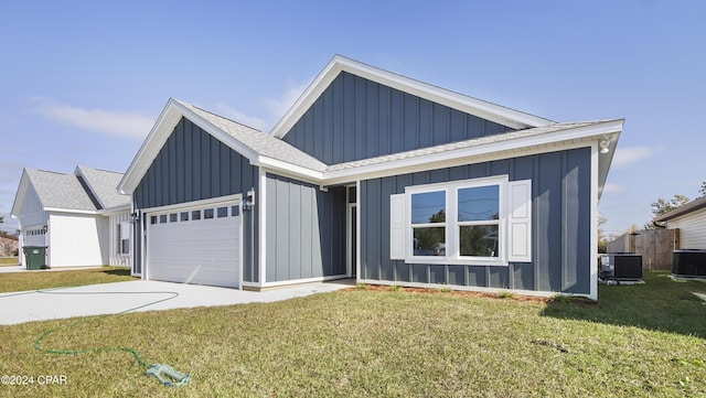 view of front of house featuring a front lawn, central AC unit, and a garage