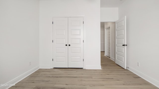 unfurnished bedroom featuring a closet and light hardwood / wood-style flooring