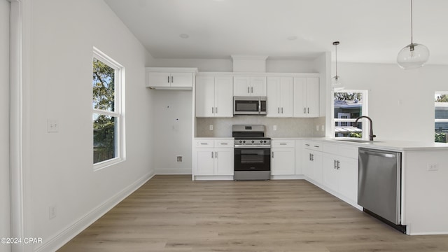 kitchen featuring white cabinets, appliances with stainless steel finishes, backsplash, and a sink