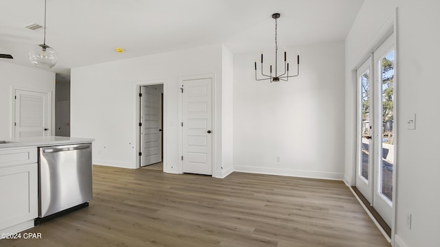 unfurnished dining area with light wood-style floors, visible vents, baseboards, and a chandelier