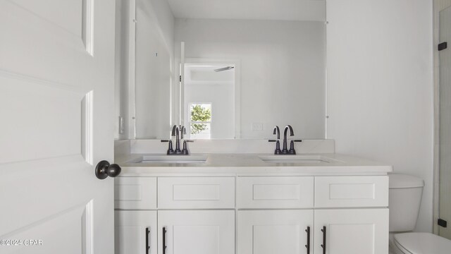 bathroom with vanity, a shower with shower door, and toilet