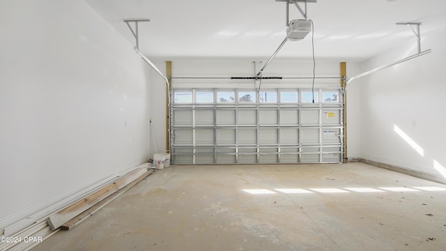 garage featuring a garage door opener and baseboards