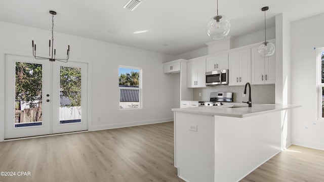 kitchen with visible vents, white cabinets, light countertops, appliances with stainless steel finishes, and decorative backsplash