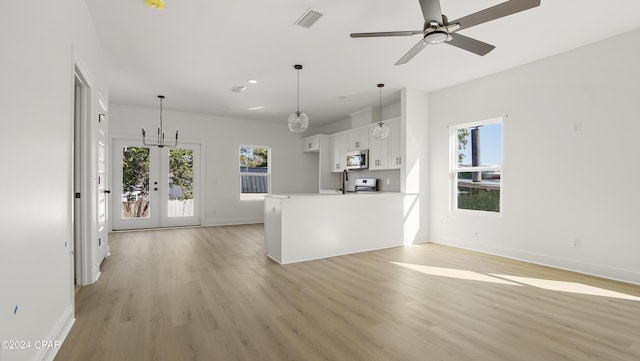 kitchen with stainless steel appliances, visible vents, white cabinetry, and light wood-style flooring