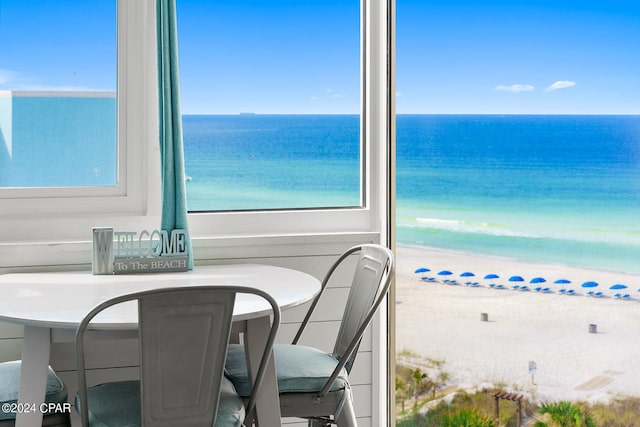 dining area featuring plenty of natural light, a view of the beach, and a water view