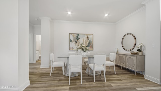 dining space with light hardwood / wood-style floors and ornamental molding