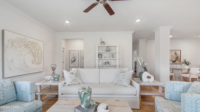 living room with ceiling fan, crown molding, and decorative columns