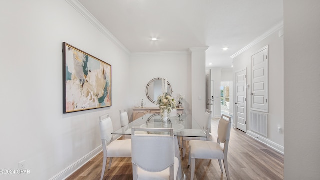 dining room featuring light hardwood / wood-style floors and crown molding