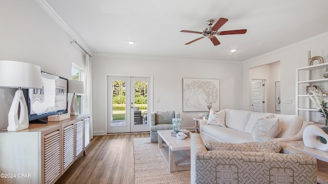 living room with hardwood / wood-style flooring, ceiling fan, and crown molding