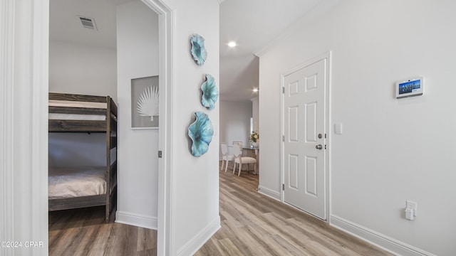 hall featuring light hardwood / wood-style floors and ornamental molding