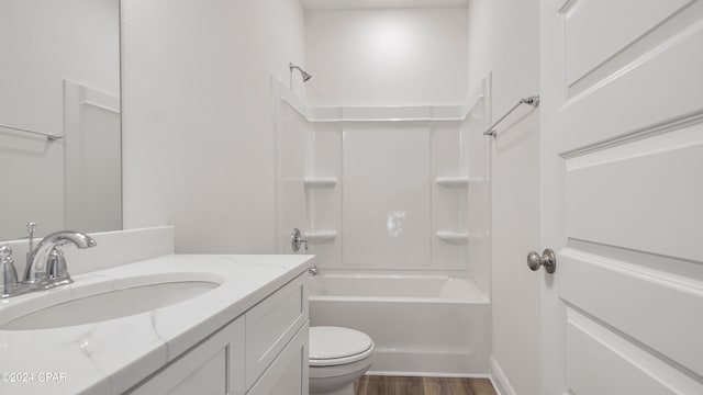 full bathroom with  shower combination, hardwood / wood-style flooring, vanity, and toilet