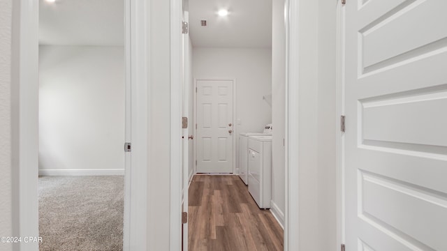 hallway with hardwood / wood-style floors and washer and dryer