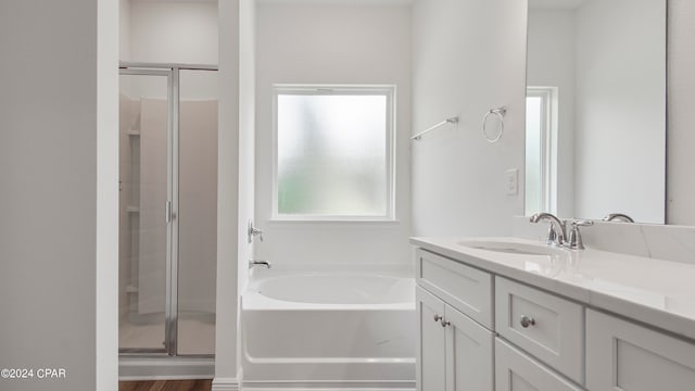 bathroom with independent shower and bath, vanity, and hardwood / wood-style flooring