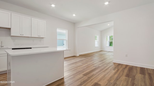 kitchen with a center island, lofted ceiling, hardwood / wood-style floors, and white cabinets