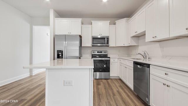 kitchen with white cabinetry, hardwood / wood-style floors, and stainless steel appliances