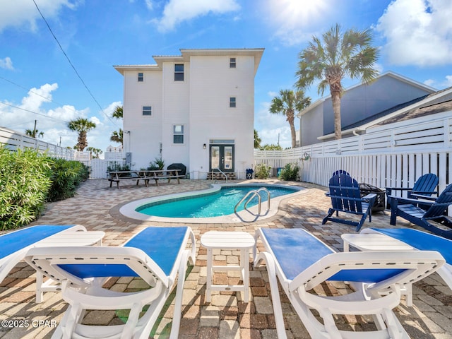 view of pool featuring a patio area, a fenced backyard, a fenced in pool, and french doors