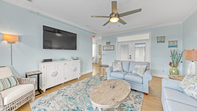 living room with light wood-type flooring, ceiling fan, french doors, and crown molding