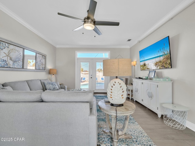 living room featuring plenty of natural light, french doors, crown molding, and wood finished floors