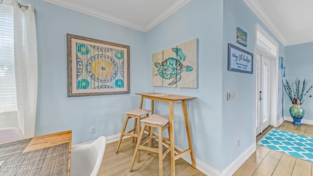 dining area featuring light hardwood / wood-style flooring and crown molding