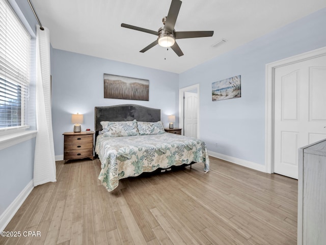 bedroom featuring baseboards, visible vents, ceiling fan, and wood finished floors