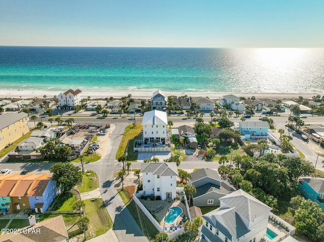 drone / aerial view featuring a beach view, a residential view, and a water view