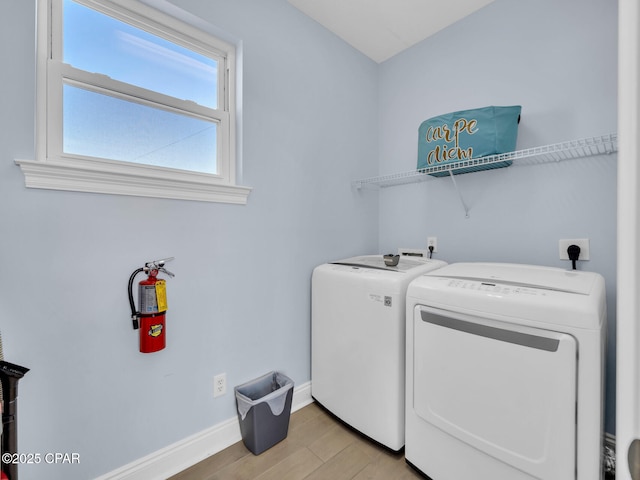 laundry area featuring light wood-type flooring, laundry area, baseboards, and washer and clothes dryer