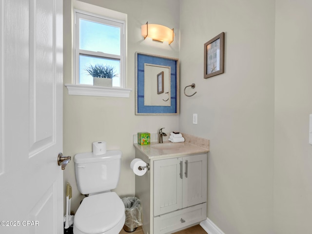 bathroom with vanity, toilet, and baseboards