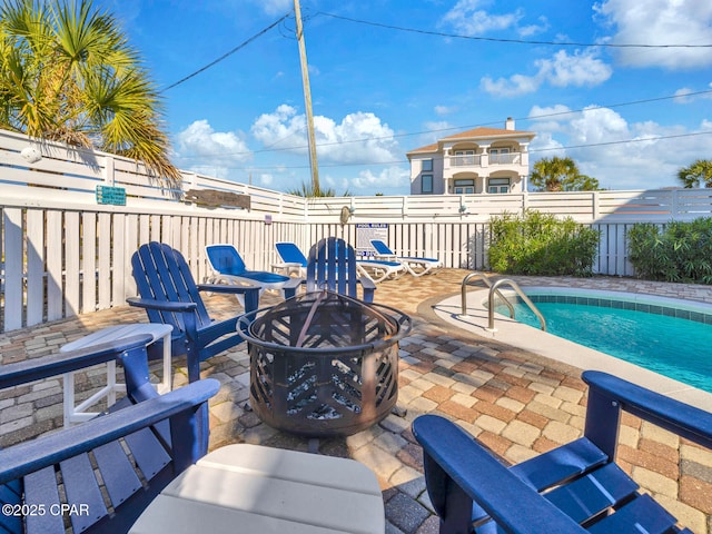 view of patio with an outdoor fire pit, a swimming pool, and fence