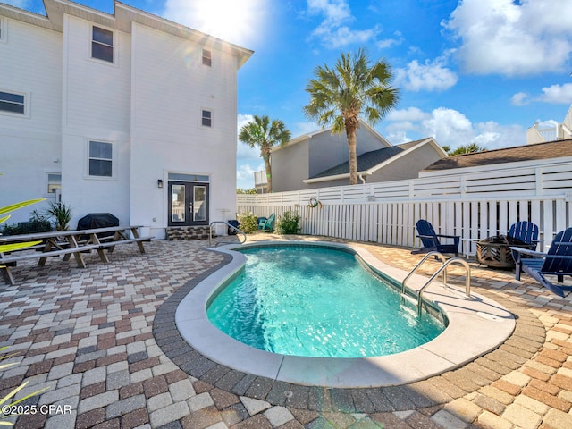 view of swimming pool with french doors, a patio area, and a fenced backyard