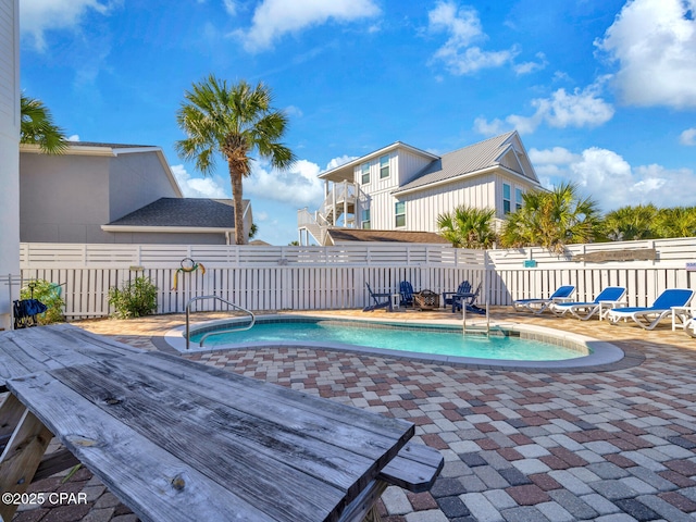 community pool featuring a patio area and a fenced backyard