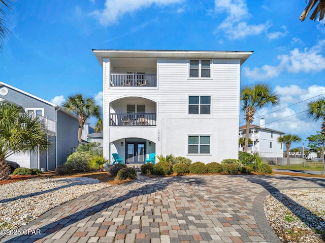 coastal home with a balcony and french doors