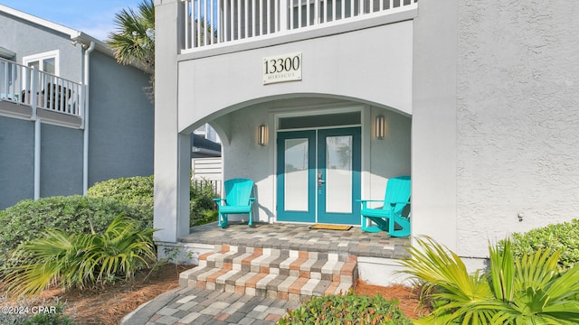 doorway to property with a balcony and french doors