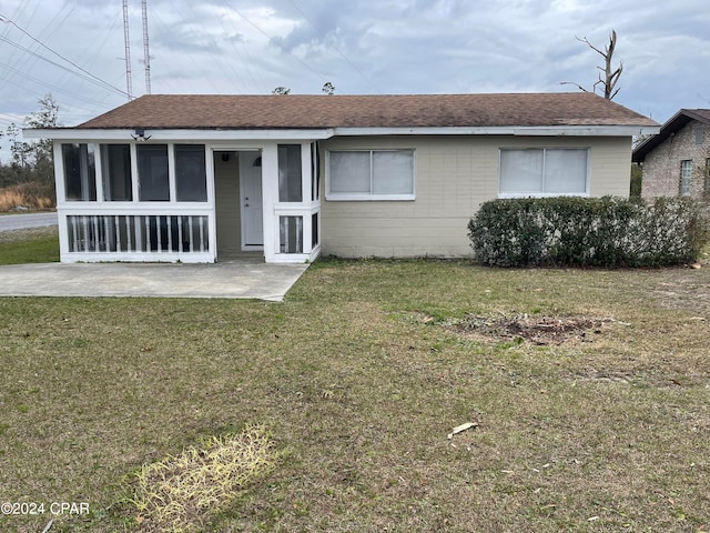 ranch-style home with a front lawn and a patio