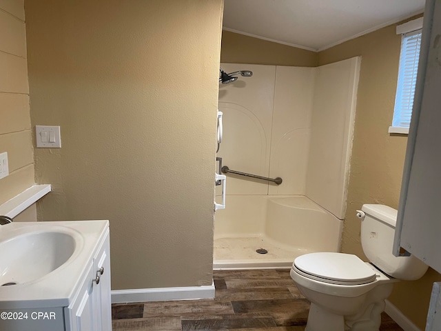 bathroom with hardwood / wood-style flooring, walk in shower, toilet, lofted ceiling, and vanity