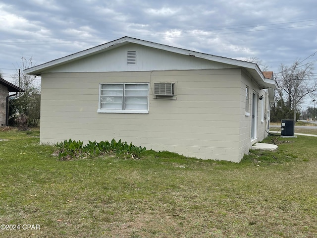 view of side of home featuring central AC unit and a lawn