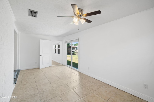 spare room with a textured ceiling, ceiling fan, and light tile patterned floors