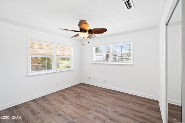 empty room featuring ceiling fan, hardwood / wood-style flooring, and crown molding