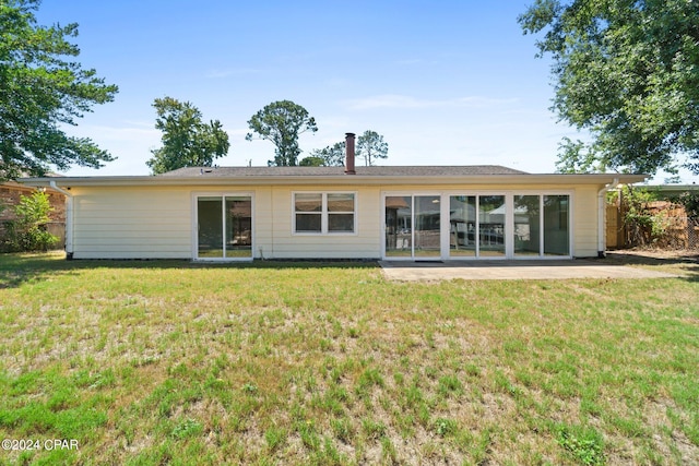 back of house featuring a patio area and a lawn