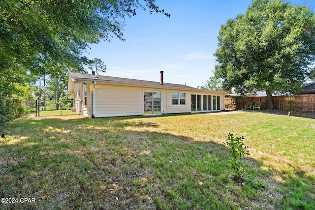 rear view of property with a lawn