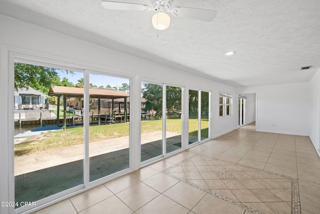 tiled empty room featuring a textured ceiling and ceiling fan