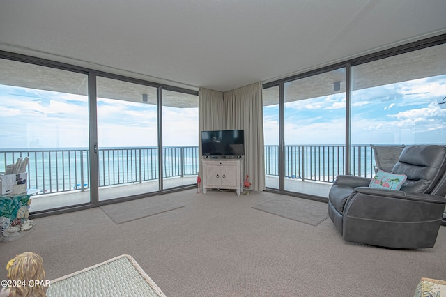 living room with a water view, expansive windows, and carpet