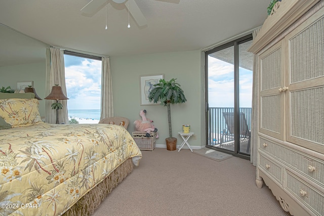 carpeted bedroom featuring a water view, ceiling fan, and access to exterior