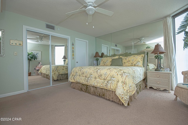 carpeted bedroom featuring multiple windows, ceiling fan, and a textured ceiling