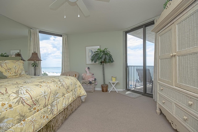 carpeted bedroom featuring multiple windows, a water view, access to exterior, and ceiling fan