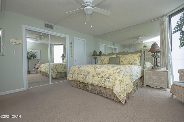 carpeted bedroom with ceiling fan and a textured ceiling