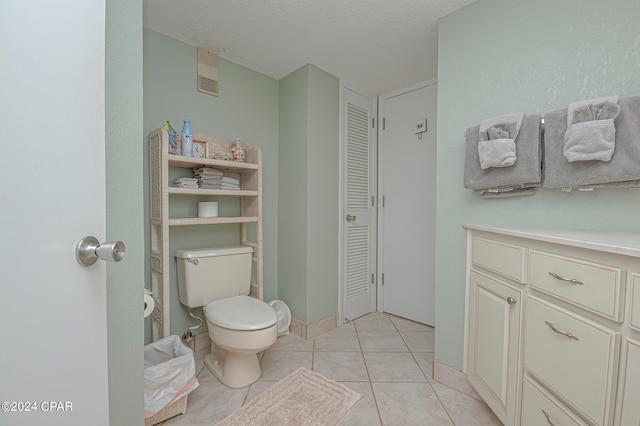 bathroom featuring tile patterned flooring, toilet, vanity, and a textured ceiling