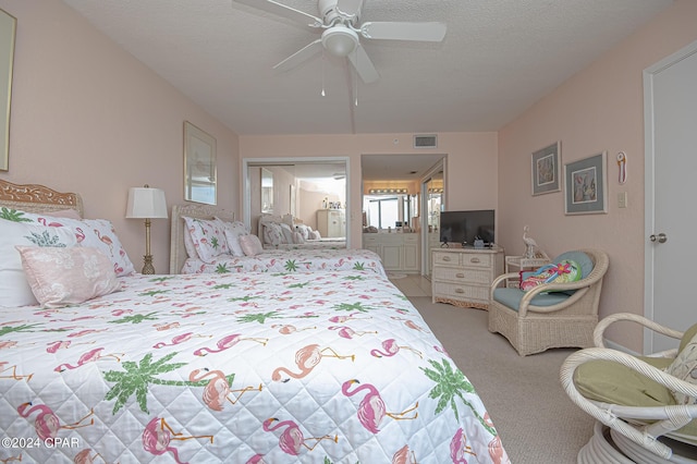 carpeted bedroom with ceiling fan, ensuite bath, and a textured ceiling