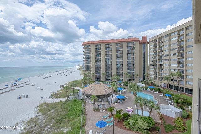 view of building exterior featuring a water view and a beach view