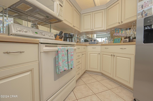 kitchen featuring light tile patterned floors, white appliances, and cream cabinetry