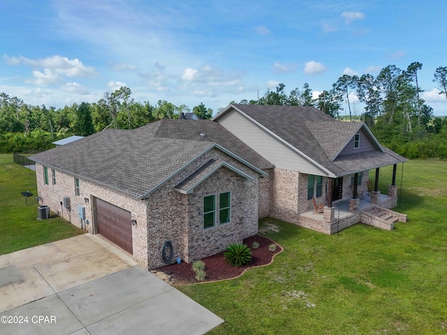 craftsman inspired home with cooling unit, a front lawn, and a garage